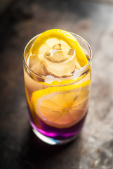 Gin based colorful cocktail with lemon and lavender liqueur on the rustic background. Selective focus. Shallow depth of field.
