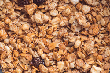 Useful and tasty muesli with nuts, rasins and flakes. Selective focus macro shot with very shallow depth of field. Healthy and vegetarian lifestyle