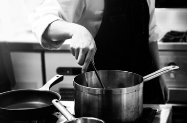 Fototapeta na wymiar Chef cooking in a kitchen, chef at work, Black & White.