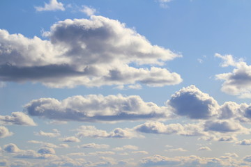Obraz premium Clouds in the blue sky at sunset or dawn backlit by the sun. Place for text and design.
