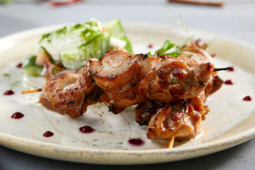 Chicken hip barbecue with homemade fresh vegetable salad in beige plate