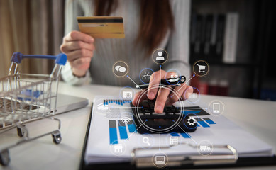 Online payment of hands of women holding credit cards and using calculator and laptop computers for online shopping.