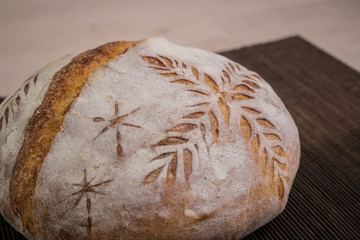 Home made traditional loaf of bread in slovenia with carved images of leaves and grain wheat on the...