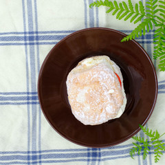 German Berliner doughnut with raspberry jam filling on background. Macro image of a donut with jam. Homemade dessert. Famous sweets.
