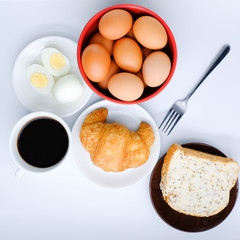 Croissant on white plate and coffee on white background. the view from the top