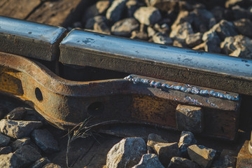 Detail of temporary fix of broken or cracked rail or railway track due to cold temperatures. View of a cracked rail track with a metal plate screwed and welded over it. Cracking of rail tracks due to 