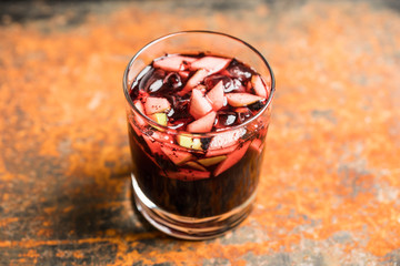 Old fashioned cocktail with blackberry liqueur and apple slices on rustic background. Selective focus. Shallow depth of field.