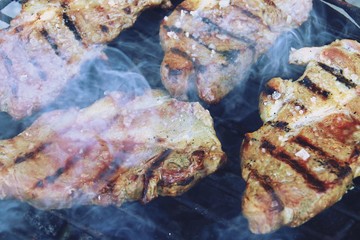 Obraz na płótnie Canvas Asando chuletones de cerdo ibérico en una barbacoa con carbón vegetal.