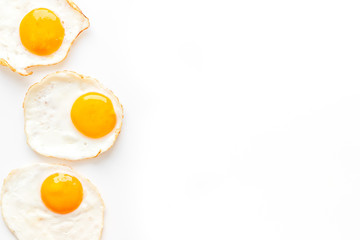 Fried eggs frame on white table top view copy space