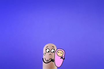 A finger is decorated as a mother. She is holding a new born baby. She is worried as she has no enough breast milk for her baby.