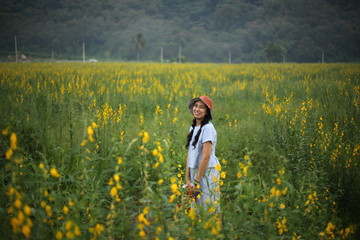 A woman standing in the crotalaria juncea field in Rayong, Thailand