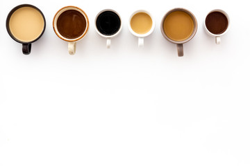 Cups of hot drinks on white background from above frame copy space