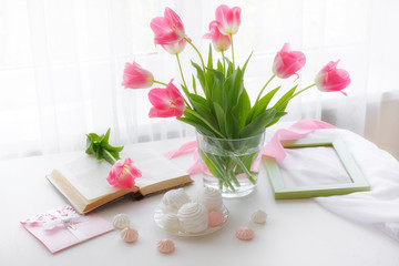 a vase of flowers is on the window a Cup of tea marshmallows, a good morning card