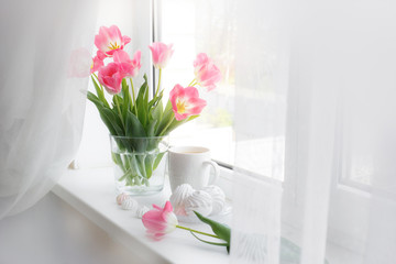 a vase of flowers is on the window a Cup of tea marshmallows, a good morning card