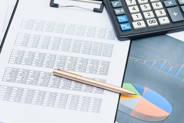 Business financial documents, office calculator and pen on the table. Numbers and graphs