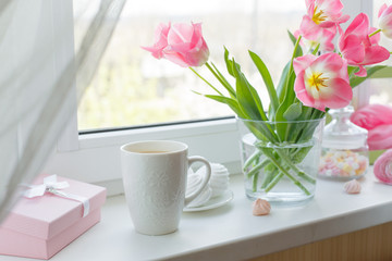 a vase of flowers is on the window a Cup of tea marshmallows, a good morning card