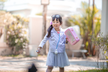 Fototapeta premium Close-up background view of a cute girl, who is experimenting with learning outside the classroom during the holidays, medical simulations to treat animals using accessories