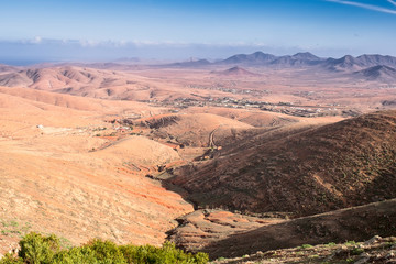 Volcanic mountains panorama with rocky desert terrain , blue cloudy sky, Fuerteventura, Canary Islands, Spain .