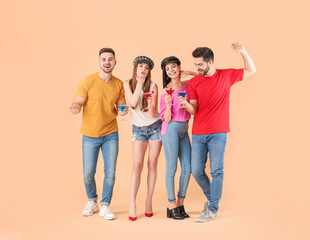 Obraz premium Happy young people with cocktails on color background