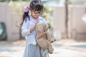 Close-up background view of a cute girl, who is experimenting with learning outside the classroom during the holidays, medical simulations to treat animals using accessories
