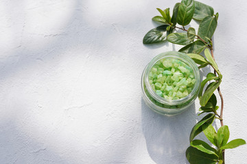 sea salt with herbs green leaves on light background , copy space