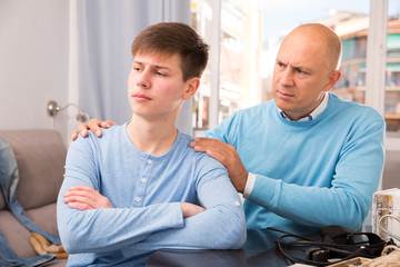 Father supporting his upset son