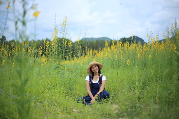 A woman sitting in the crotalaria juncea field in Rayong, Thailand