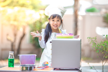 Close-up view of an Asian girl, cute looking at cooking, business learning concepts in food plans and online marketing.