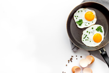 Fried eggs on frying pan on white background top view copy space