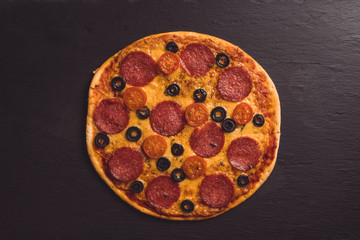 Fresh pepperoni pizza served on the rustic background. Selective focus. Shallow depth of field.