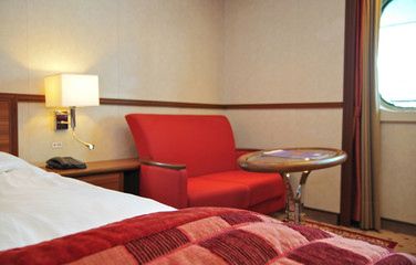 Living room area inside balcony cabin or veranda suite onboard Hurtigruten expedition cruiseship or...