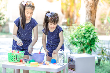 Close-up background view of cute Asian girls,who are experimenting with cooking or mixing food colors, concepts of learning to live life in a family,and studying new perspectives outside of the class