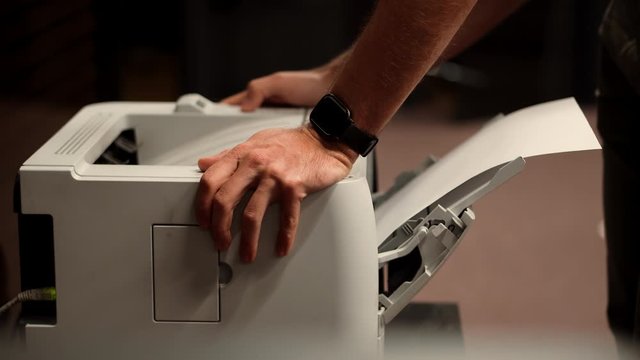 Man Using Printer In Office.