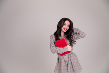 Beautiful girl student business women with red notebook on white, grey background.