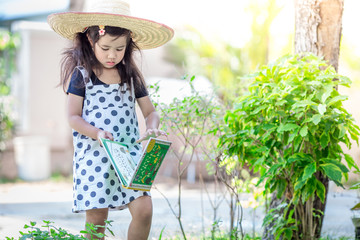 Close-up background view of a cute girl who is watering plants or growing vegetables for health,a crop cultivation program and business expansion