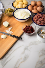 Zutaten  für Norddeutscher Hamburger Labskaus mit Rindfleisch Corned Beef, Rote Beete, Kartoffeln, Saure Gurken, Zwiebeln, Ei und Rollmops auf Marmor Arbeitsfläche