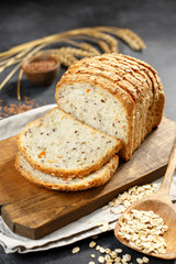 Bread on a wooden background, eggs, flour in a bowl, rye, bread knife, cereals