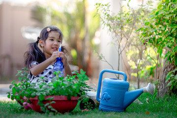 Close-up background view of a cute girl who is watering plants or growing vegetables for health, a crop cultivation program and business expansion.