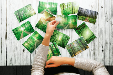 a woman looking at photos, remember nostalgia for a day of rest walking in the forest. Spring photo