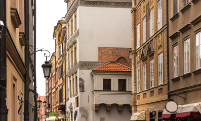 The roofs of medieval houses and the church tower in the Old Town. Lantern in the foreground. Winter season in Warsaw, Poland.