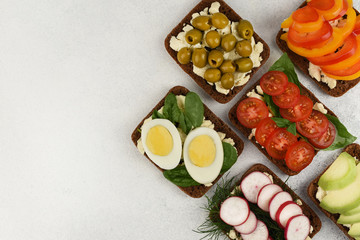 Open sandwiches on white stone background with copy space. Vegetables open faced homemade sandwiches top view.