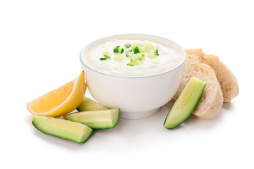 Delicious yogurt sauce with cucumber in bowl on white background