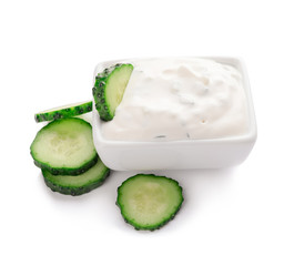 Delicious yogurt sauce with cucumber in bowl on white background