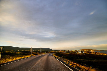 View on the road and interesting landscape with tundra, village and cloudy sky. Landscape in Norway