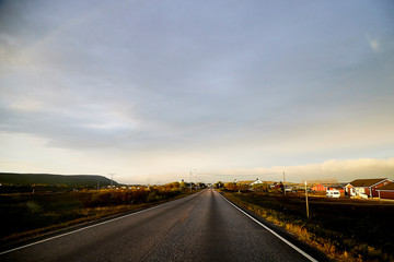 View on the road and interesting landscape with tundra, village and cloudy sky. Landscape in Norway
