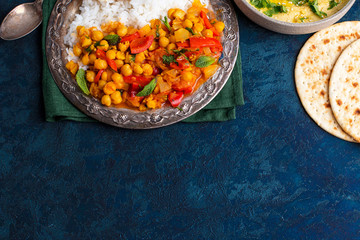 vegan food, hummus, rice, chickpeas with vegetables, pita bread on a blue background