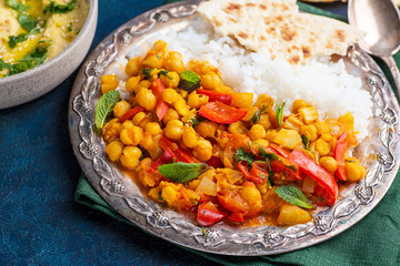 vegan food, hummus, rice, chickpeas with vegetables, pita bread on a blue background