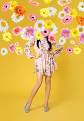 Creative spring fashion composition. Posing girl and flowers splash