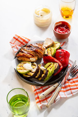 Grilled meat and vegetables with sauce on light table, healthy food close up
