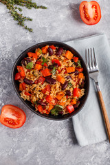 brown rice with vegetables on a grey background